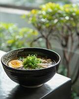Amidst a serene setting, a bowl of bland organic ramen broth offers a gentle, soothing base for a personalized culinary journey photo