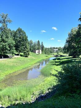 a river runs through a park with trees and grass photo