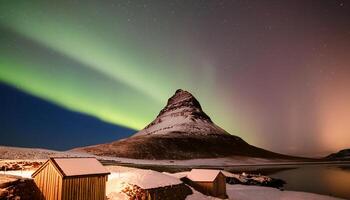 A mountain with a green aurora is in the background. There are two small houses in the foreground photo