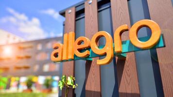Warsaw, Poland. 8 June 2024. View of the Allegro Group logotype on the wooden wall with ivy. A modern residential building in the background. photo