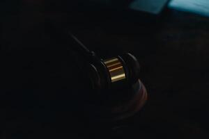 Justice and law concept.Male judge in a courtroom with the gavel, working with, computer and docking keyboard, eyeglasses, on table in morning light photo
