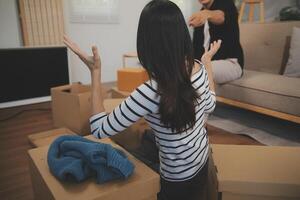 Two Asian blogger showing clothes in front of the camera to recording vlog live streaming at her shop. Online Shopping Cart notion. on sofa at home photo