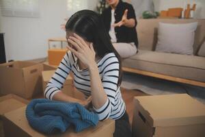 Two Asian blogger showing clothes in front of the camera to recording vlog live streaming at her shop. Online Shopping Cart notion. on sofa at home photo