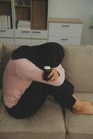Depressed woman sitting alone on the bed with hands on head feel stress, sad and worried in the dark bedroom and low light environment photo