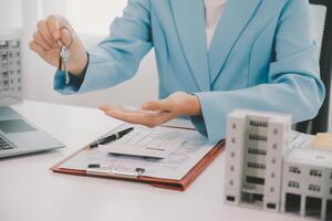 Real estate agent talked about the terms of the home purchase agreement and asked the customer to sign the documents to make the contract legally, Home sales and home insurance concept. photo