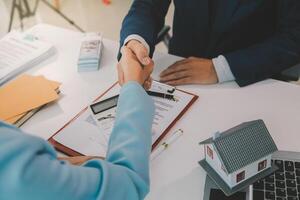 Real estate agent talked about the terms of the home purchase agreement and asked the customer to sign the documents to make the contract legally, Home sales and home insurance concept. photo