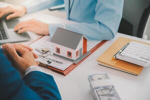Real estate agent talked about the terms of the home purchase agreement and asked the customer to sign the documents to make the contract legally, Home sales and home insurance concept. photo