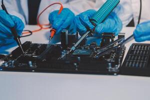Close up of Technician measuring voltage electronic circuit board television, Service after sale fix electric equipment within insurance. photo