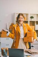 Portrait of Starting small businesses owners female entrepreneurs working on receipt box and check online orders to prepare to pack the boxes, sell to customers, sme business ideas online. photo