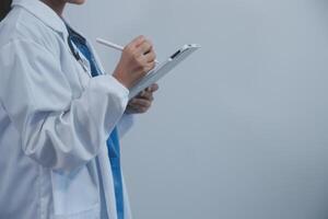 Woman doctor using tablet computer while standing straight in hospital photo
