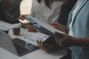 Financial analysts analyze business financial reports on a digital tablet planning investment project during a discussion at a meeting of corporate showing the results of their successful teamwork. photo