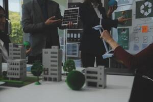 Business people having consultation about wind energy at company office. Business team discussing about windmill and alternative green energy. Executive meeting at modern office photo