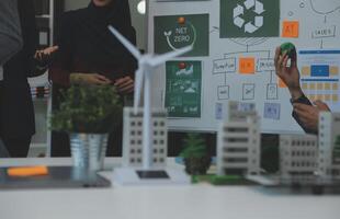 Business people having consultation about wind energy at company office. Business team discussing about windmill and alternative green energy. Executive meeting at modern office photo