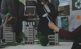 Business people having consultation about wind energy at company office. Business team discussing about windmill and alternative green energy. Executive meeting at modern office photo