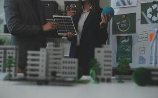 Business people having consultation about wind energy at company office. Business team discussing about windmill and alternative green energy. Executive meeting at modern office photo
