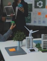 Business people having consultation about wind energy at company office. Business team discussing about windmill and alternative green energy. Executive meeting at modern office photo