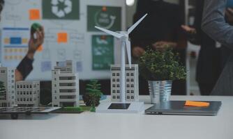 Business people having consultation about wind energy at company office. Business team discussing about windmill and alternative green energy. Executive meeting at modern office photo