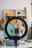 Young woman freelancer working sme business online shopping and packing clothes with cardboard box at home - Business online shipping and delivery concept photo