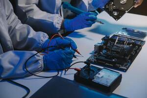 Close up of Technician measuring voltage electronic circuit board television, Service after sale fix electric equipment within insurance. photo