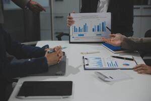 Business team collaboration discussing working analyzing with financial data and marketing growth report graph in team, presentation and brainstorming to strategy planning making profit of company. photo