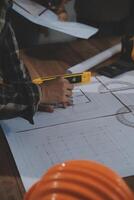 Team of multiethnic architects working on construction plans in meeting room. Engineers discussing on project in office. Mature businessman and woman standing around table working on blueprint. photo