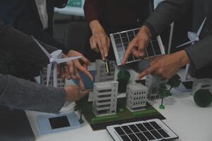 Business people having consultation about wind energy at company office. Business team discussing about windmill and alternative green energy. Executive meeting at modern office photo