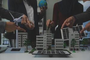 Business people having consultation about wind energy at company office. Business team discussing about windmill and alternative green energy. Executive meeting at modern office photo