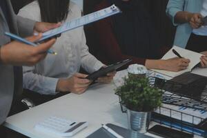 Financial analysts analyze business financial reports on a digital tablet planning investment project during a discussion at a meeting of corporate showing the results of their successful teamwork. photo