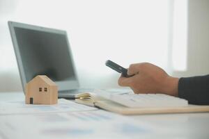 Businessmen holding pens, signing home titles with insurance, care about real estate services and the idea of real estate agents offering interest in installments to their customers. photo