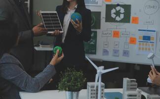 Business people having consultation about wind energy at company office. Business team discussing about windmill and alternative green energy. Executive meeting at modern office photo