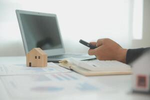 Businessmen holding pens, signing home titles with insurance, care about real estate services and the idea of real estate agents offering interest in installments to their customers. photo