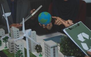 Business people having consultation about wind energy at company office. Business team discussing about windmill and alternative green energy. Executive meeting at modern office photo