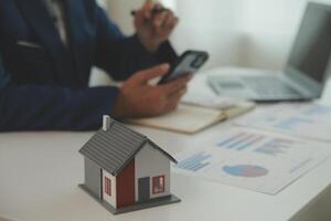 Businessmen holding pens, signing home titles with insurance, care about real estate services and the idea of real estate agents offering interest in installments to their customers. photo