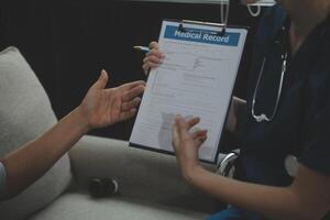 Female caregiver doing regular check-up of senior woman in her home. photo
