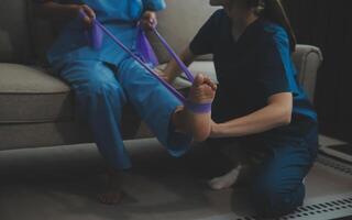 Unrecognizable senior physiotherapist working with a female patient. photo