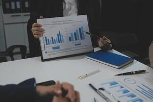 Business team collaboration discussing working analyzing with financial data and marketing growth report graph in team, presentation and brainstorming to strategy planning making profit of company. photo