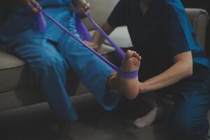Unrecognizable senior physiotherapist working with a female patient. photo