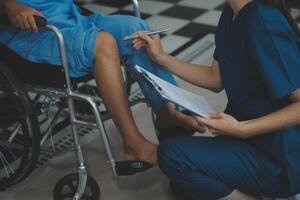 Young physiotherapist exercising with elder disabled person photo
