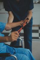 Personal trainer assisting senior woman with resistance band. Rehabilitation physiotherapy worker helping old patient at nursing home. Old woman with stretch band being coached by physiotherapist. photo