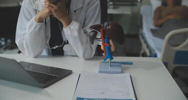 Female doctor explaining to patient results of model the process of patients. Diagnosis of diseases for Model Internal organ. photo