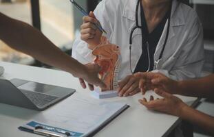 Female doctor explaining to patient results of model the process of patients. Diagnosis of diseases for Model Internal organ. photo