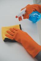 Woman cleaning table using rag and diffuser at home. photo