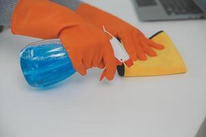 Woman cleaning table using rag and diffuser at home. photo
