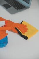 Woman cleaning table using rag and diffuser at home. photo