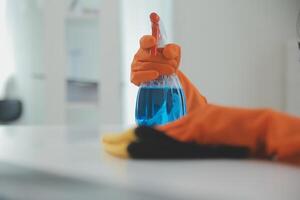 Woman cleaning table using rag and diffuser at home. photo