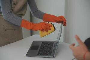 Woman cleaning table using rag and diffuser at home. photo