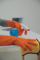Woman cleaning table using rag and diffuser at home. photo