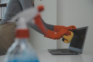 Woman cleaning table using rag and diffuser at home. photo