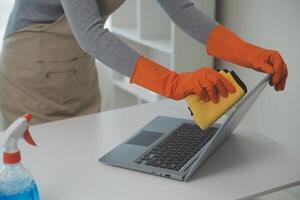 Woman cleaning table using rag and diffuser at home. photo