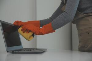 Woman cleaning table using rag and diffuser at home. photo